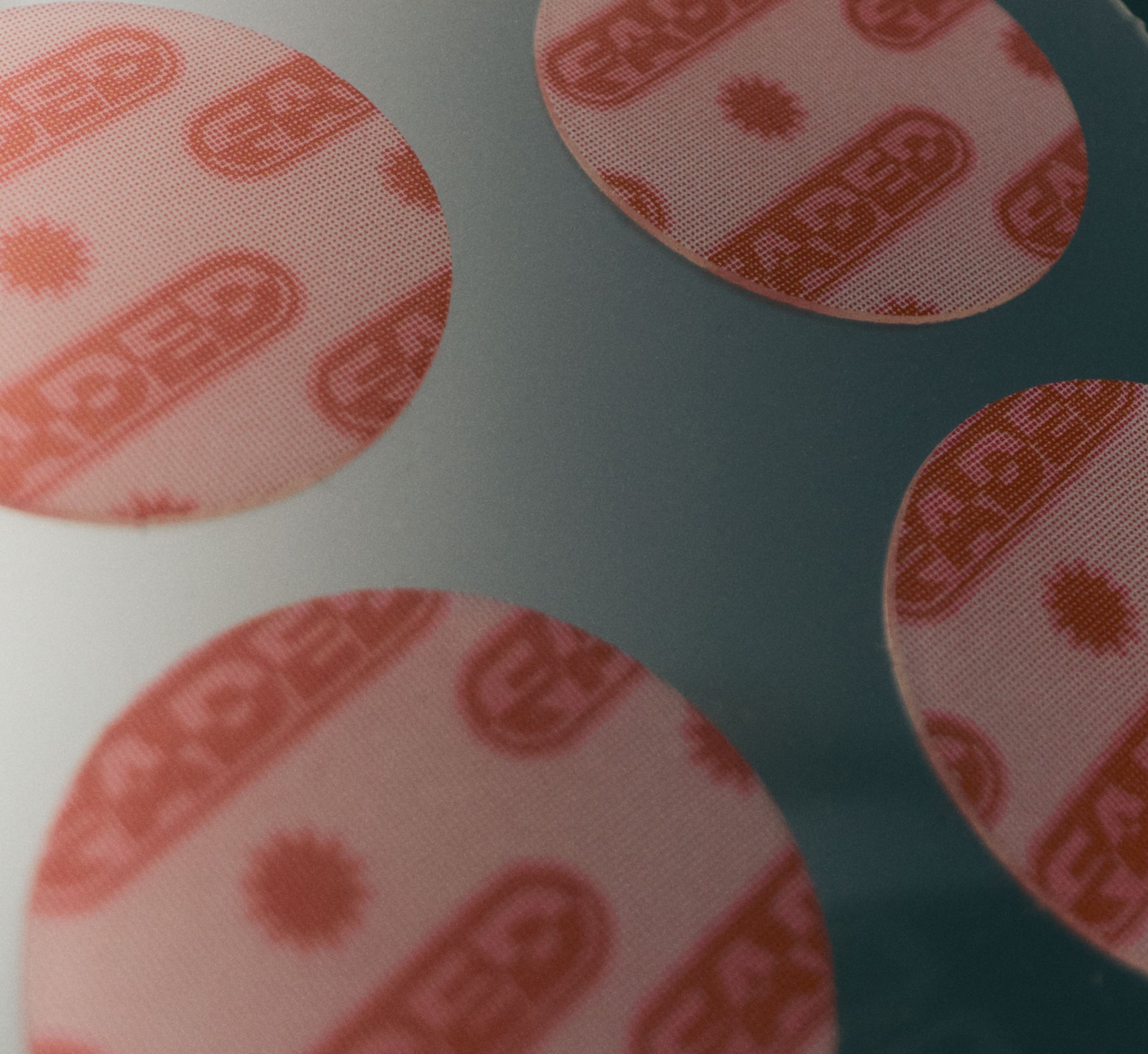 Dark spot remover patches from Topicals Faded shown in a close-up macro shot highlighting the translucent round patches with a red branded print.